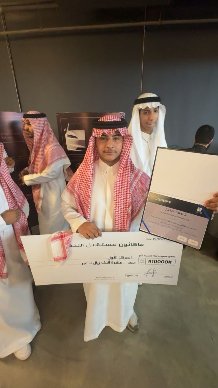 Holding the first-place cheque at the Future of Mobility Hackathon
